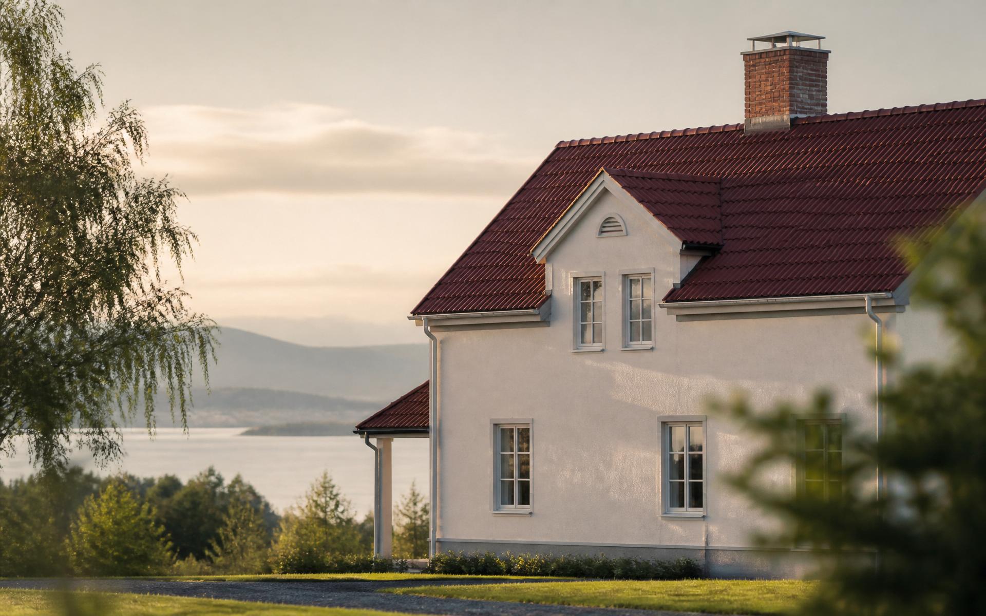 Putsat hus i Jämtland med tegelskorsten och utsikt över Storsjön
